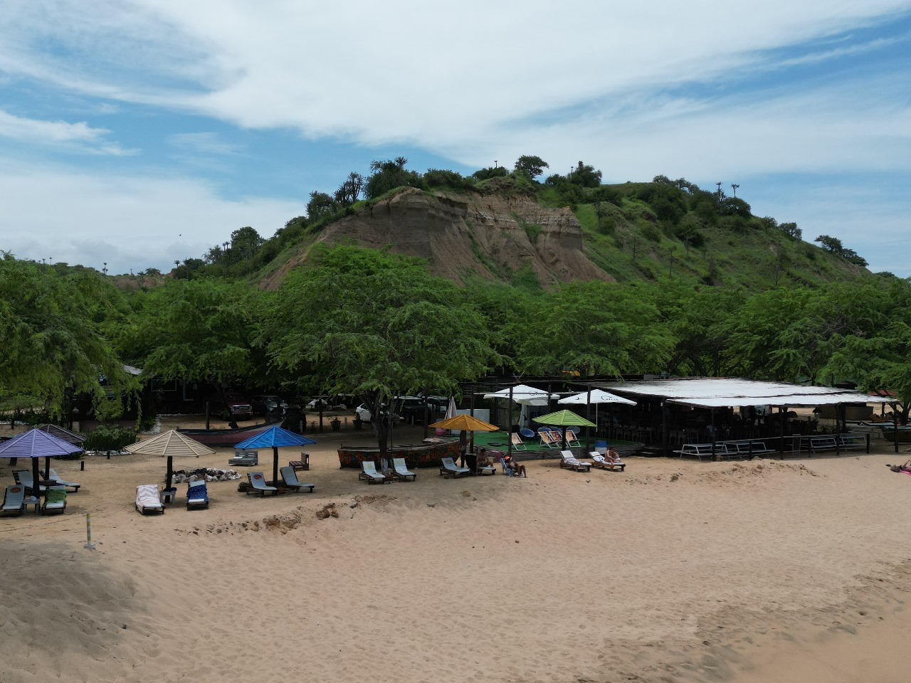 Vista panorâmica da área de lazer do resort com guarda‑sóis coloridos na praia