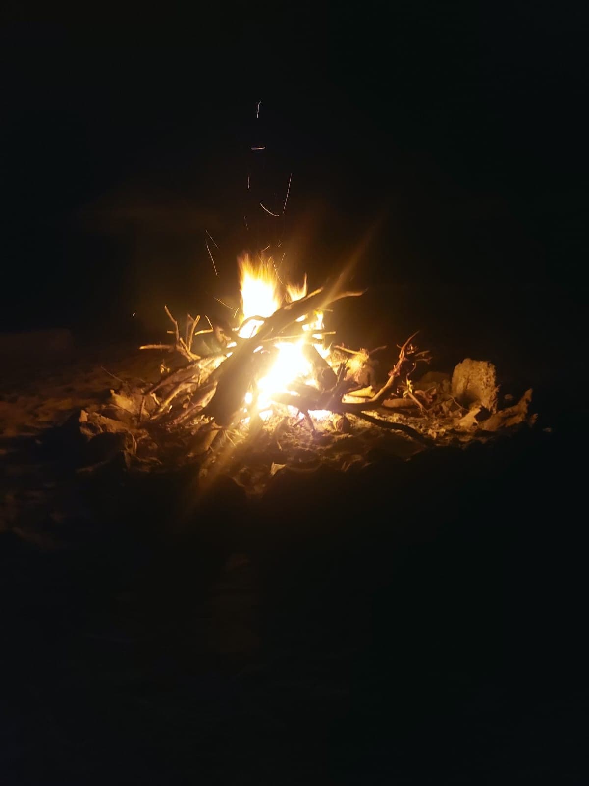 Foto — fogueira acesa na praia à noite